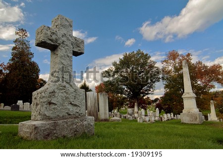 Ancient New England cemetery with a grave stone sculpture of a cross. Dating back to the late 1700\'s.