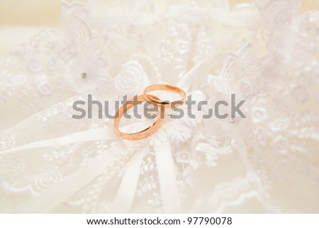 Gold wedding rings on a wedding dress of the bride.