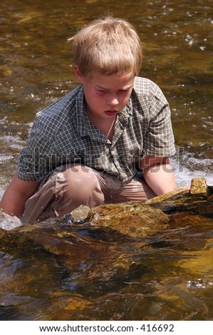 Boy cooling off in Minnehaha Creek, Minneapolis on a hot summer day
