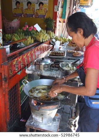 BANGKOK, THAILAND - MAY 18: Man preparing food in an open roadside restaurant May 18, 2005 in Bangkok.