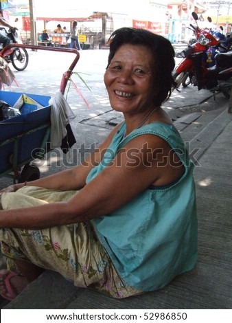 BANGKOK, THAILAND - SEPTEMBER 7: Old Thai lady sits by the street 7, 2007 in Bangkok.