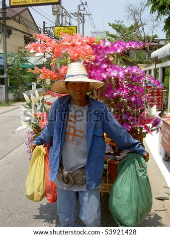 PATTAYA, THAILAND - MARCH 15: Thai man selling religious flowers from his cart on March 15, 2006 in Pattaya.