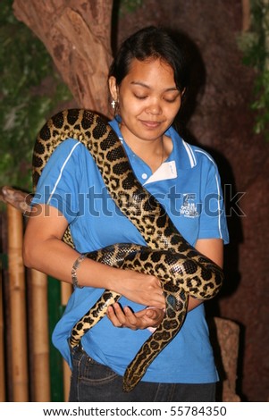 BANGKOK, THAILAND - JULY 23: Thai woman holds a snake for students in Siam ocean world on July 23, 2008 in Bangkok.