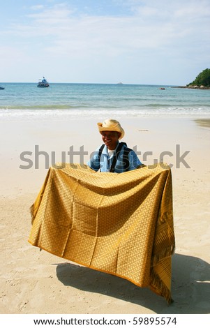 KOH SAMET, THAILAND - AUGUST 25: Thai man sells Thai silk to tourists on the beach on August 25, 2010 in Koh Samet.