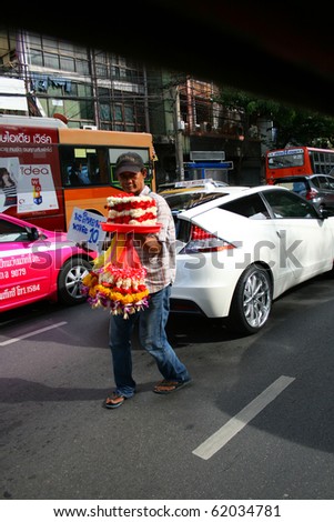 BANGKOK - SEPTEMBER 24: Thai man sells Buddhist flowers on the road on September 24, 2010 in Bangkok, Thailand.