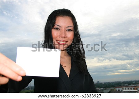 Asian woman holding white card.