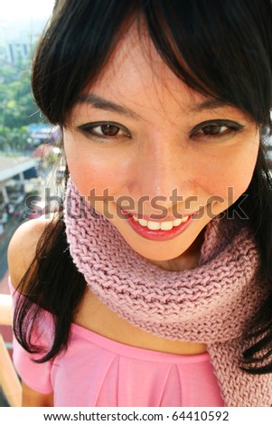 Beautiful asian girl outdoors wearing scarf.