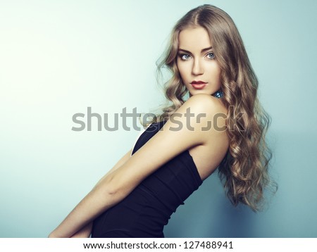 Portrait Of Beautiful Young Blonde Girl In Black Dress. Fashion Photo