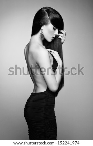 Portrait of beautiful brunette woman in black dress. Fashion photo