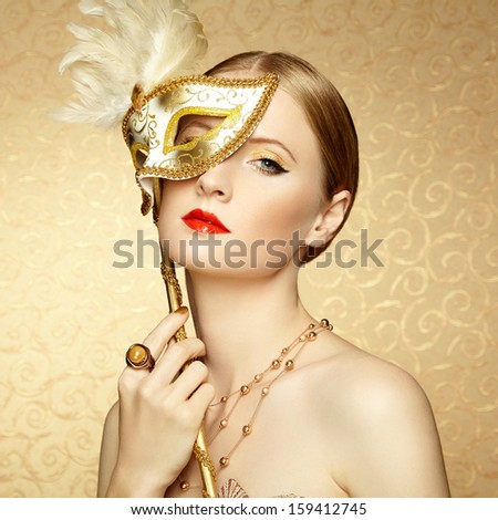 Beautiful Young Woman In Mysterious Golden Venetian Mask. Fashion Photo