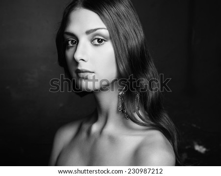 Portrait of beautiful young woman with earring. Fashion photo