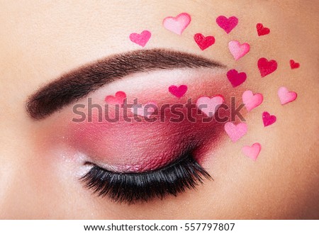 Eye make-up girl with a heart. Valentine\'s day makeup. Beauty fashion. Creative woman holiday make-up