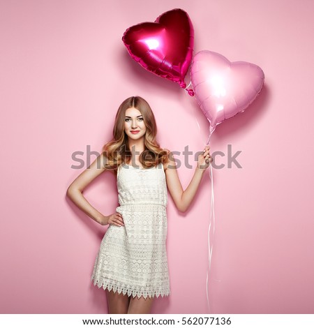 Beautiful young woman with heart shape air balloon on color background. Woman on Valentine\'s Day. Symbol of love