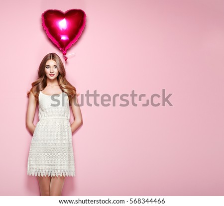 Beautiful young woman with heart shape air balloon on color background. Woman on Valentine\'s Day. Symbol of love