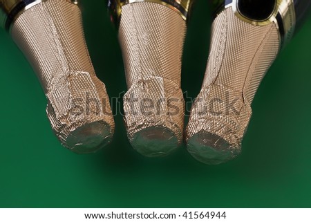 Three bottles of champagne on a green background