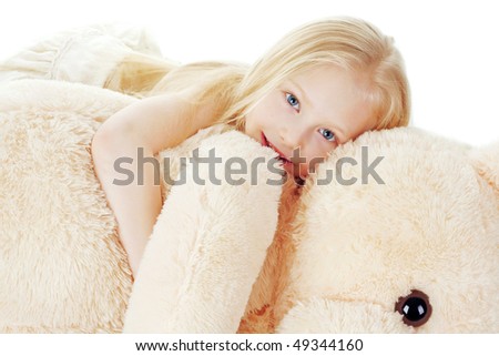 The beautiful girl embraces a plush bear