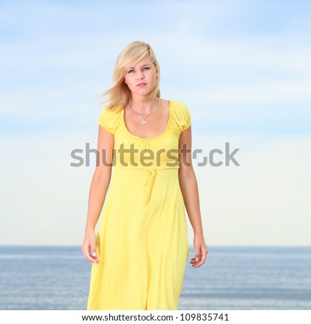 Romantic Beautiful smiling girl in the yellow dress water beach