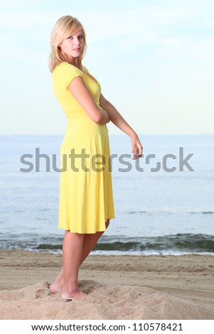 Romantic Beautiful smiling girl in the yellow dress water beach