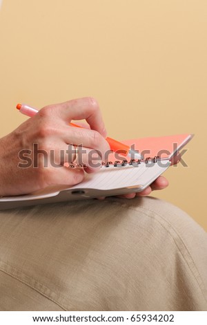 Notebook and a red pen in the hands of women