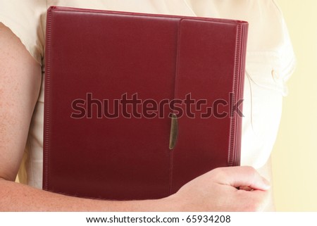 The woman holds the business book for notes