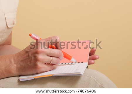 Notebook and a red pen in the hands of women