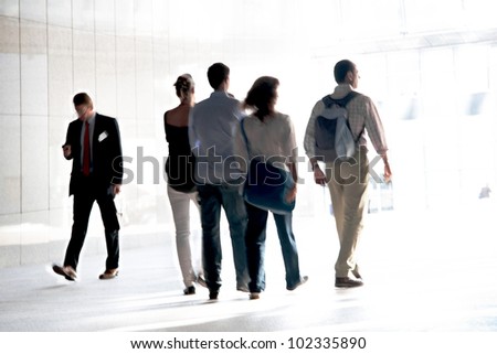 People walking against a light background. Walking businessmen against a background of an urban landscape.