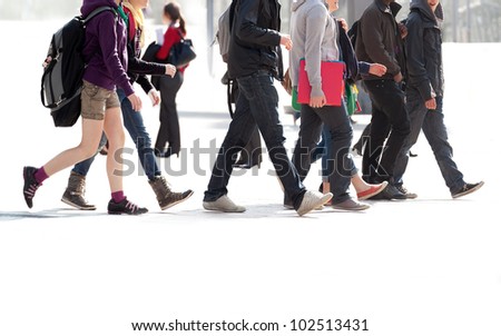 A crowd moving against a background of an urban landscape. Young people. Motion blur.