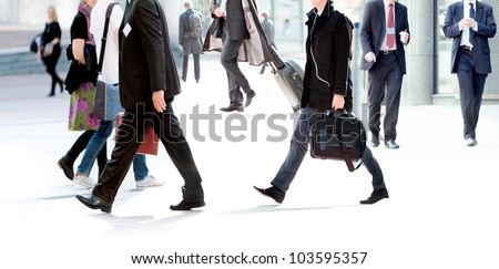 People walking against the light background of an urban landscape. Motion blur.
