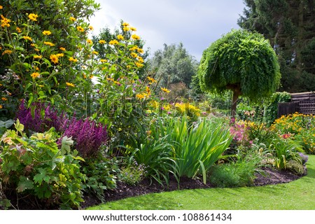 Green lawn in a colorful landscaped formal garden. Beautiful Garden.