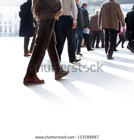 The big group of older persons. People walking against a light background.