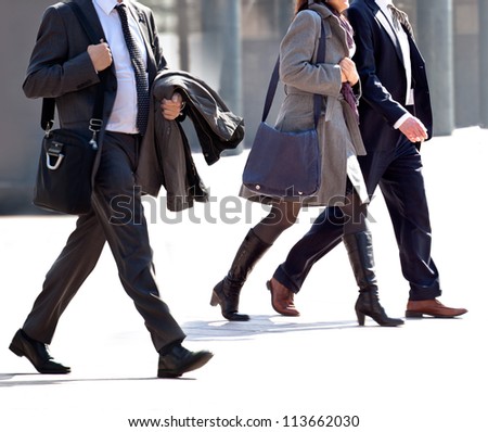 Walking businessmen and business women in the downtown. Motion blur.
