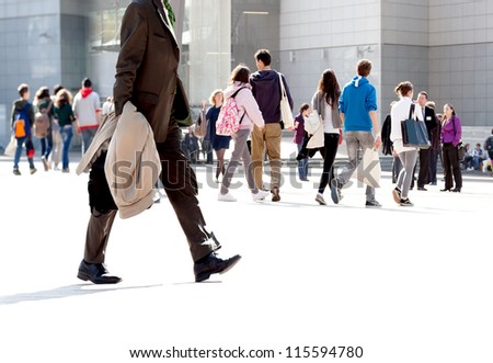 Walking businessman. A group of young people and businessmen walking on the background of the urban landscape. Urban landscape.