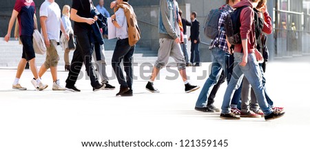 A large group of young people walking. The urban landscape.