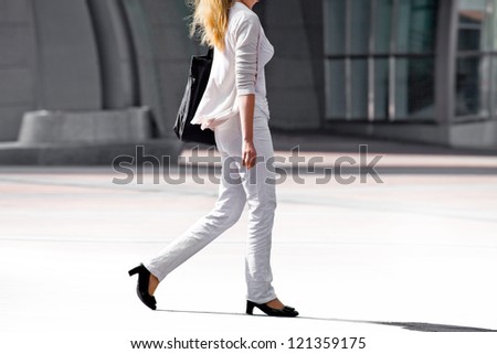 Business woman walking on the background of the office. The modern woman.