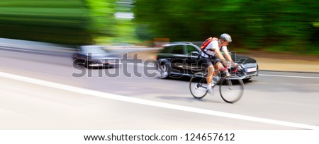 Blurred motion. Cyclist and car on the highway. Abstract background.