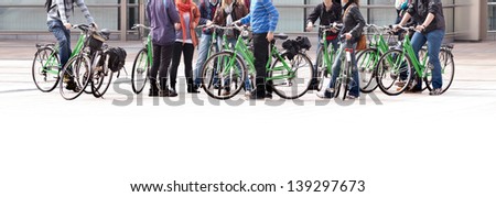 A large group of cyclists. Rent bikes. Urban scene.