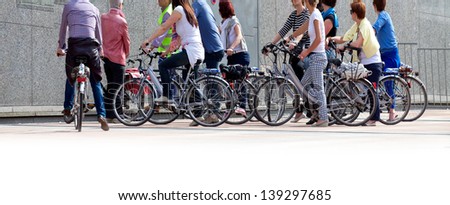 A large group of cyclists. Rent bikes. Urban scene.