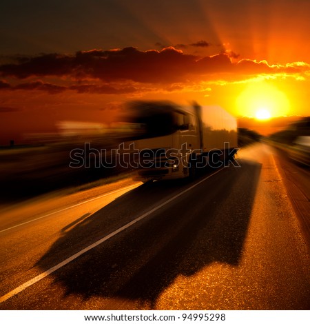 The truck on highway. A sunset.