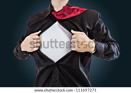 Young business man tearing apart his shirt revealing a superhero suit