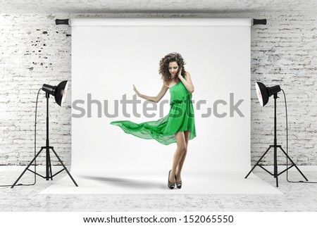 young beautiful woman in green dress posing in studio
