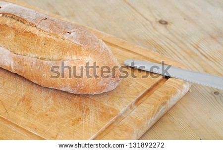 Italian bread on weathered wooden cutting board, selective focus