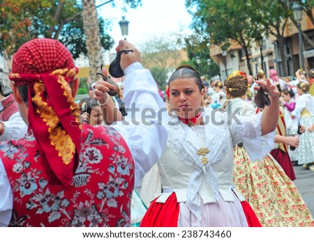 VALENCIA, SPAIN - NOVEMBER 9, 2014: traditional Valencian street party where inhabitants of all ages dance dressed in beautiful, original, handmade clothes and with typical hairstyle