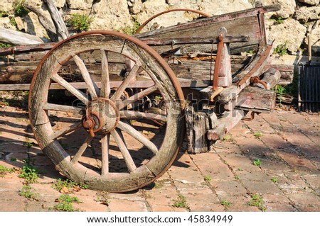 Old broken-down wooden cart with rusty wheels