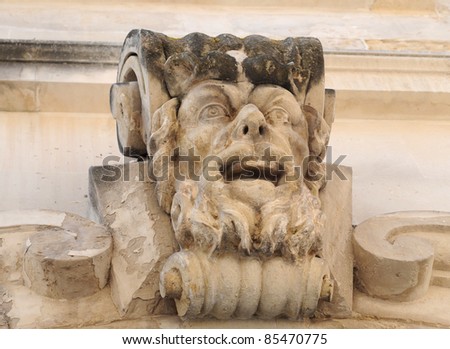 Antique male stone head on a wall in Lecce, Italy, Europe