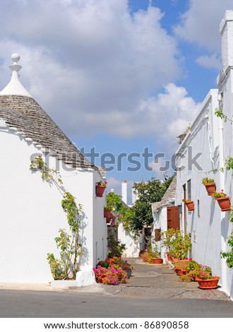 Trulli houses with conical roofs and lots of flowerpots in Alberobello, Italy, Europe