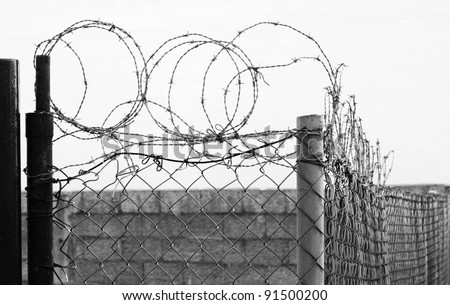 Secured area with barbed wire and fence, black and white