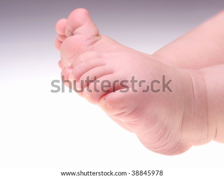 Cute baby feet, one foot with curled toes and other stretched.