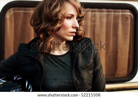 girl in leather jacket looks far away
