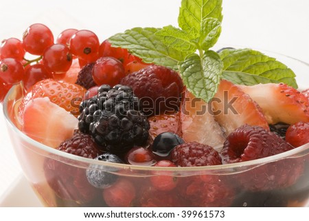 Fruit salad.Assorted berries in orange juice.Red fruits dessert. Close-up.