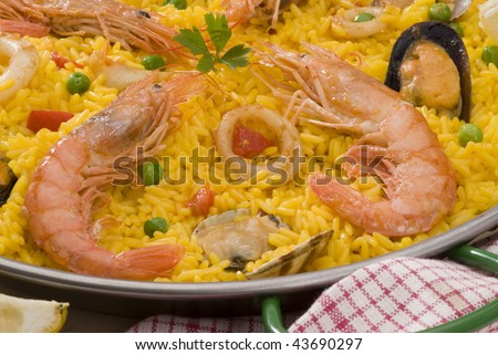Spanish Cuisine. Paella. Spanish rice with red wine and oranges in background.Closeup. Selective focus.
